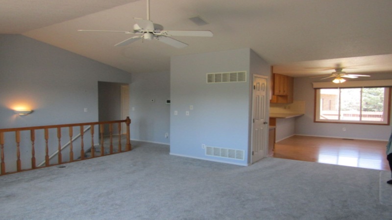 View of dining room, hallway to bedrooms and basement stairs from living room